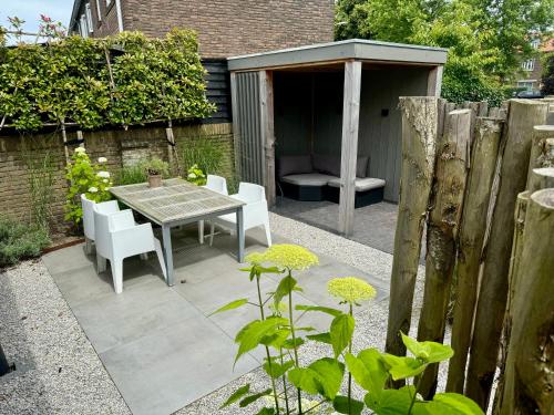 a garden with a table and chairs and a shed at Private Tiny House in Bussum near Amsterdam! in Bussum