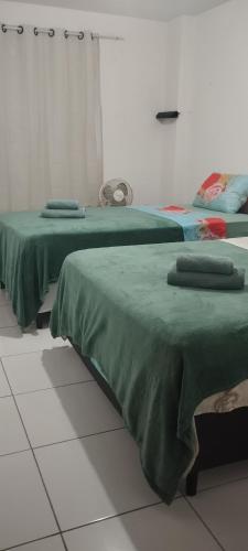two beds sitting next to each other in a room at Residencial Ilha de Capri in Campina Grande