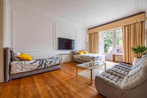 a living room with two couches and a tv at Viktoria B & B in Brussels