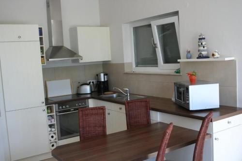 una cucina con tavolo con sedie e forno a microonde di Ferienwohnung In Karnin a Karnin