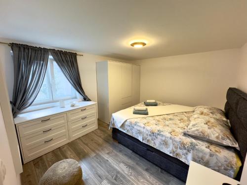 a bedroom with a bed with a dresser and a window at Apartman Meld in Vrh