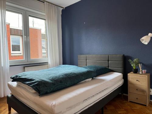 a bedroom with a bed with a blue wall at Nathanael Ferienwohnung mit Küche, WLAN & 4 Schlafzimmern in Werne an der Lippe