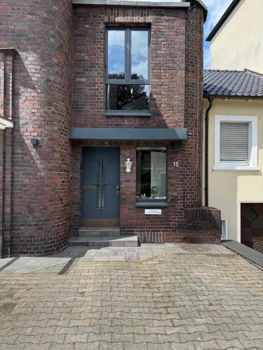 a brick house with a blue door and windows at Nathanael Ferienwohnung mit Küche, WLAN & 4 Schlafzimmern in Werne an der Lippe