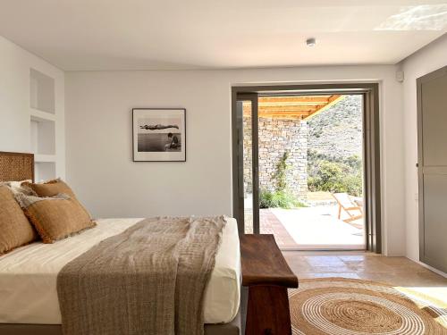 a bedroom with a bed and a sliding glass door at Egeo Paros in Kampos Paros