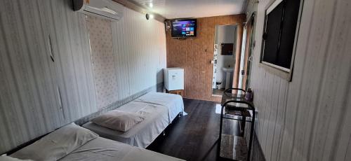 a room with two beds and a television in it at Pousada de Containers in Alter do Chao