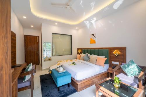 a bedroom with a large white bed and a table at Perfectstayz Premium Mystic falls with Rooftop Pool & Cafe in Narendranagar