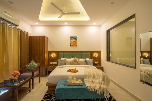 a bedroom with a bed and a ceiling fan at Perfectstayz Premium Mystic falls with Rooftop Pool & Cafe in Narendranagar