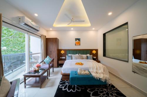 a bedroom with a large bed and a balcony at Perfectstayz Premium Mystic falls with Rooftop Pool & Cafe in Narendranagar
