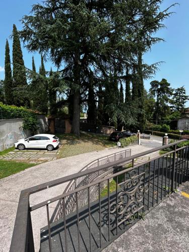 a fence with a car parked in a parking lot at Hotel Bellevue in Gardone Riviera