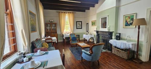 a living room filled with furniture and a fireplace at Kelkiewyn Guesthouse Caledon in Caledon
