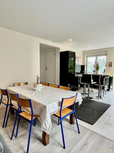 une salle à manger avec une table et des chaises blanches dans l'établissement Maison spacieuse avec terrasse - DABNB, à Saint-Brice-sur-Vienne