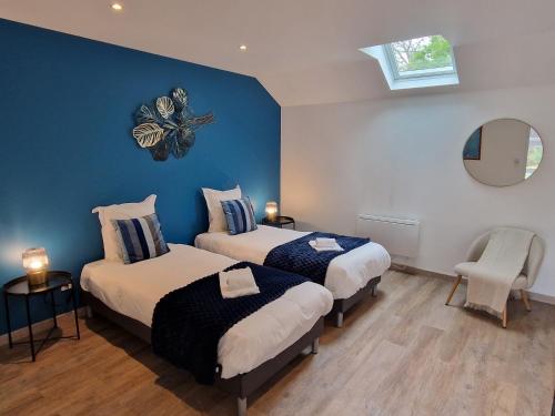 - 2 lits dans une chambre avec des murs bleus et un miroir dans l'établissement Grande maison de vacances Les Champions, à Menetou-Râtel