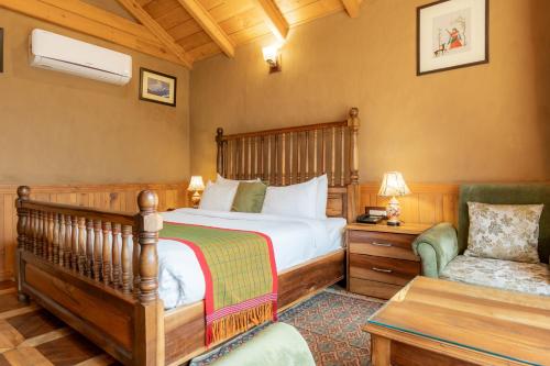 a bedroom with a bed and a couch and a chair at Shivadya - A Luxury Boutique Experience in Manāli