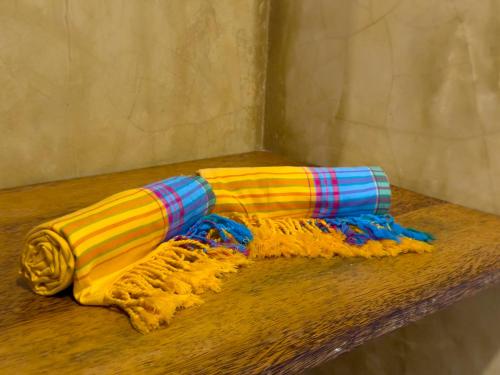 three colorful scarves are sitting on a table at The Coco Paradise in Jambiani