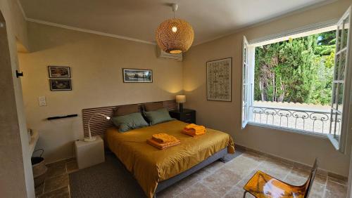 une chambre avec un lit avec des draps orange et une fenêtre dans l'établissement Villa Calou à Vaison, à Vaison-la-Romaine