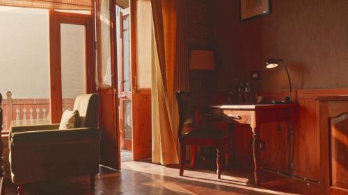 a living room with a chair and a desk at Shivadya - A Luxury Boutique Experience in Manāli