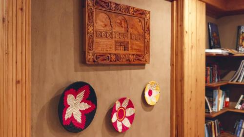 a wall with three masks hanging on a wall at Shivadya - A Luxury Boutique Experience in Manāli