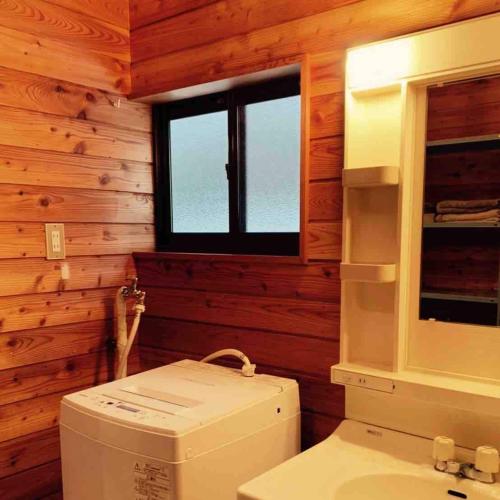 a bathroom with a toilet and a window at SAKURA BBQ home theater etc in Tsumagoi