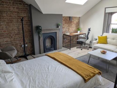 a living room with a bed and a fireplace at Digital Nomad Studio in Norwich