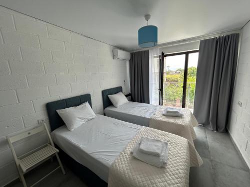 a room with two beds and a chair and a window at Cottages - Townhouses in Ureki