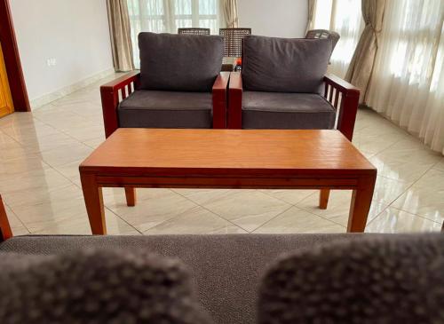 a living room with two chairs and a coffee table at Pearl Seasons BnB in Gulu