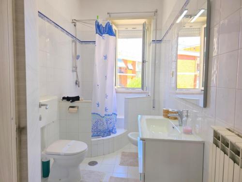 a white bathroom with a toilet and a sink at Casa Cristallo 150Mq fronte mare con posto auto in Gaeta