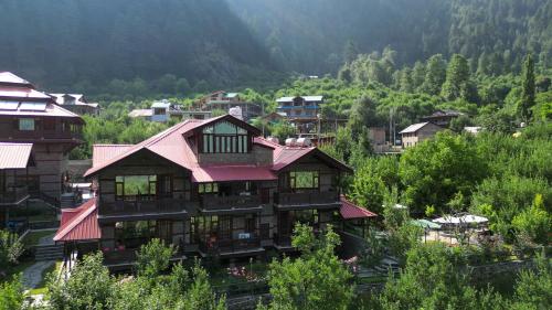 a large house with a red roof on a mountain at Shivadya - A Luxury Boutique Experience in Manāli