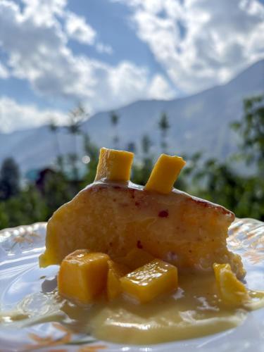 a piece of food on a plate with a desert at Shivadya - A Luxury Boutique Experience in Manāli