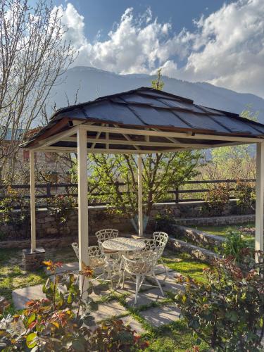 a pavilion with a table and chairs in a yard at Shivadya - A Luxury Boutique Experience in Manāli
