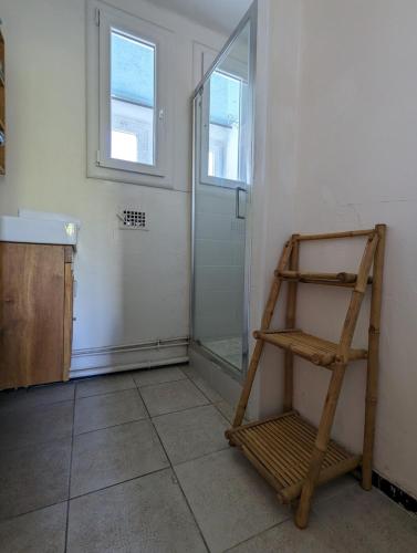 La salle de bains est pourvue d'une douche et d'une échelle en bois. dans l'établissement Le Nid de près d'arènes, à Montpellier