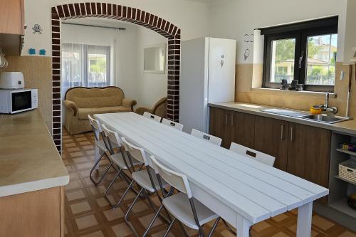 a kitchen with a white table and chairs in a room at Freedom Surf House in Serra de El-Rei