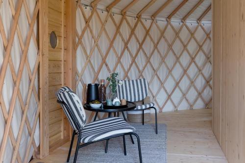 two chairs and a table in a room with a wall at DOMAINE LE MEZO in Ploeren