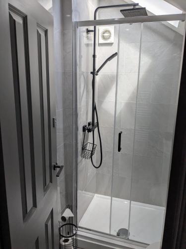 a shower with a glass door in a bathroom at Digital Nomad Studio in Norwich