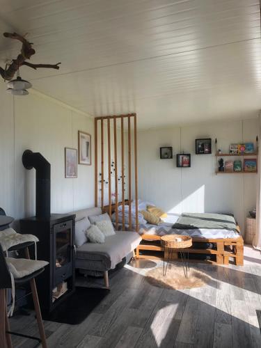 a living room with a bed and a fireplace at Sidehill - zážitkové ubytovanie v prírode in Martin
