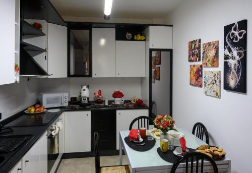 a kitchen with white cabinets and a table with food on it at ACasaMia in Manduria