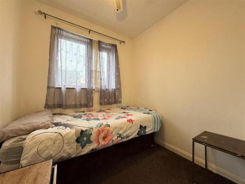 a small bedroom with a bed with a window at Olive, 3Bedrooms,1 extra Rm, Sleeps 9 with Garden, Free Parking in Grays, Lakeside, London in Grays Thurrock