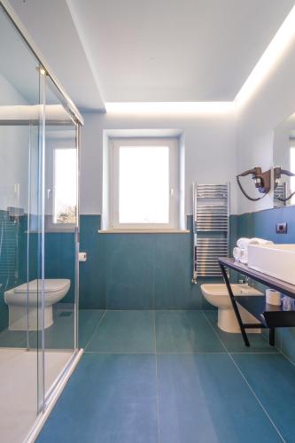 a bathroom with a shower and a toilet and a sink at Hotel Vita in Salò