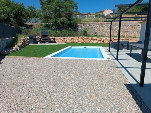 a small swimming pool in a garden with a patio at Villa avec piscine et terrain de pétanque in Trans-en-Provence