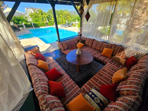 a room with a couch and a table and a pool at Villa Belle ,Fethiye in Fethiye