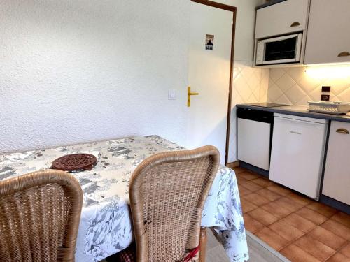une petite cuisine avec une table et des chaises dans une pièce dans l'établissement Studio + Cabine 27m² Sud - 4 pers, Grand Bornand, balcon, proche commerces et pistes - FR-1-458-120, au Grand-Bornand