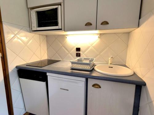 La petite salle de bains est pourvue d'un lavabo et d'un lavabo blanc. dans l'établissement Studio + Cabine 27m² Sud - 4 pers, Grand Bornand, balcon, proche commerces et pistes - FR-1-458-120, au Grand-Bornand