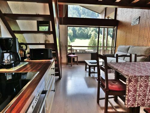 - une cuisine et un salon avec une table et un comptoir dans l'établissement Appartement 3 pièces + mezzanine, 71m², 7 pers, proche centre, balcon, garage - Grand-Bornand - FR-1-458-98, au Grand-Bornand