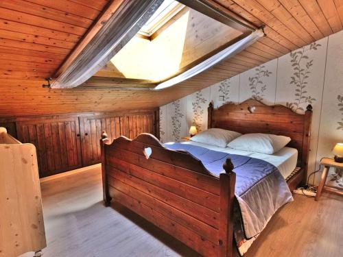 - une chambre avec un grand lit en bois et une lucarne dans l'établissement Appartement 3 pièces + mezzanine, 71m², 7 pers, proche centre, balcon, garage - Grand-Bornand - FR-1-458-98, au Grand-Bornand