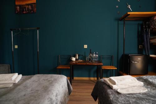 a blue room with two beds and a table at Hotel Hobbiton near Vardzia Caves in T'mogvi