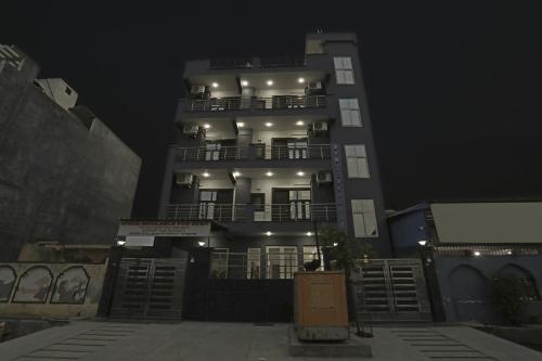 a tall building with lights on it at night at Hotel O Noida premium inn in Noida