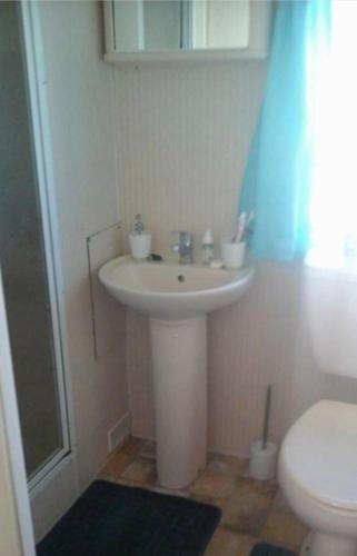 une salle de bain avec un lavabo blanc et des toilettes dans l'établissement Mv16 4 bed caravan on the Golden Palm, à Chapel St. Leonards