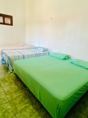 two beds sitting next to each other in a room at Paracuru HolaOnda WaveHostel in Paracuru