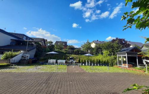 a patio with chairs and umbrellas in a yard at Blue Lagoon in Nehren
