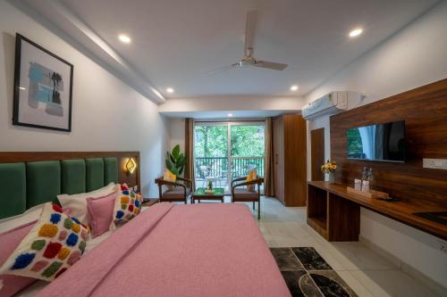 a bedroom with a pink bed and a television at Perfectstayz Premium Mystic falls with Rooftop Pool & Cafe in Narendranagar