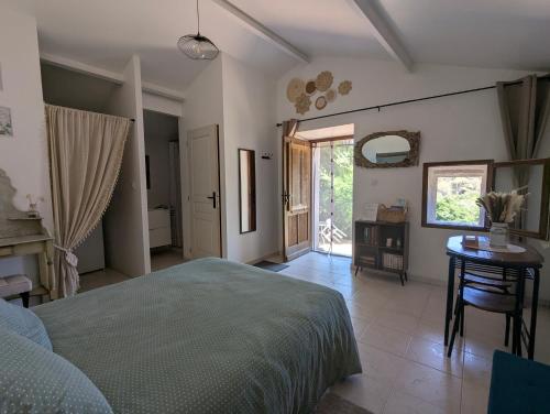 a bedroom with a bed and a table and a window at La chambre de Ptitruc au coeur du maquis in Granace